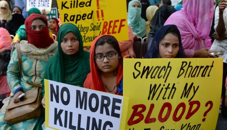 Protesters hold posters against assaults on Muslims and Dalits in India