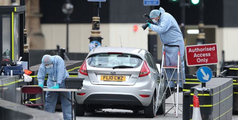 Forensic police officers work around a silver Ford Fiesta car that was driven into a barrier at the United Kingdom Houses of Parliament in central London as what is treated as a terrorism attack.