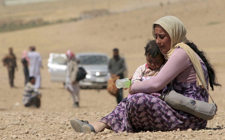 A displaced Yazidi woman and child flee violence from Islamic State in Sinjar, Iraq