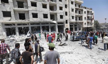 Syrians at a site of car bomb in Idlib