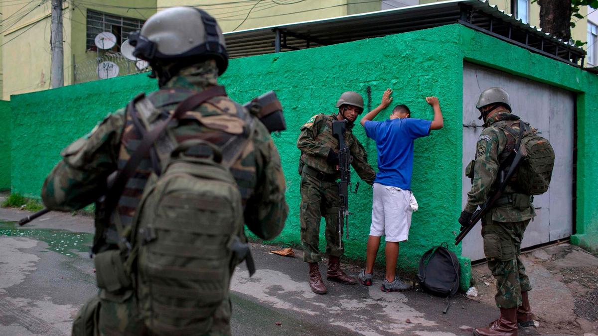 Brazilian army soldiers frisk a resident during a joint operation at the Cidade de Deus (City of God) favela in Rio de Janeiro.