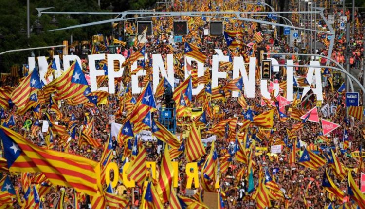 People wave pro-independence Catalan flags 'Esteladas' while holding letters reading 'independence' during a pro-independence demonstration in Barcelona, Spain