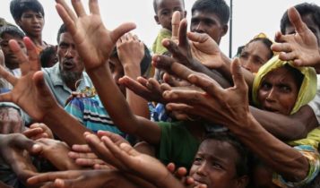 Rohingya refugees reaching for food aid at Kutupalong refugee camp in Bangladesh