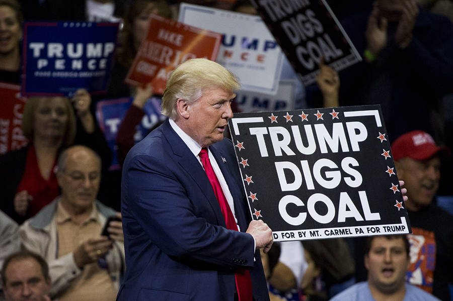 US President Donald Trump displays a sign saying 'Trump digs coal' during a rally.