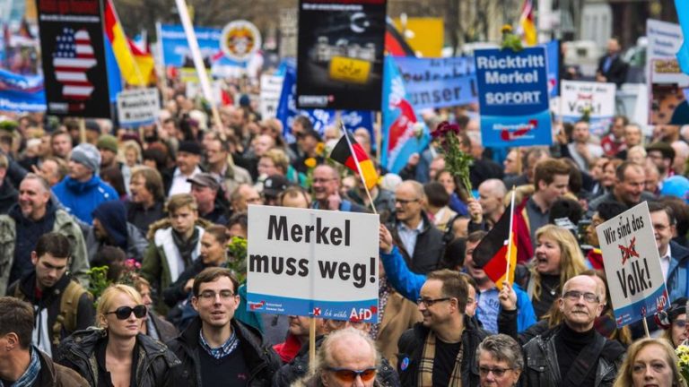 Supporters of Germany's AfD show German flags and display posters saying 'Merkel must go'