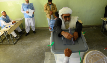 An Afghan man puts his vote in during the parliamentary elections in Afghanistan