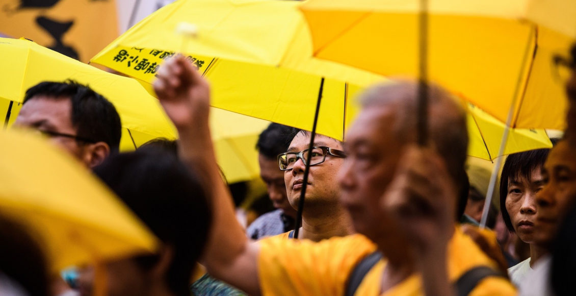 Activists use yellow umbrellas during a gathering outside the Hong Kong government headquarters to mark the fourth anniversary of mass pro-democracy rallies, known as the Umbrella Movement