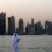 A man looks at his phone on the corniche in Qatar capital Doha