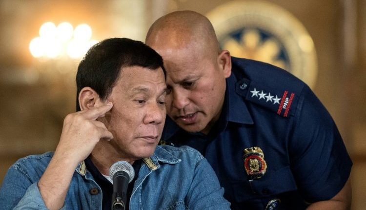 Philippine President Rodrigo Duterte, left, talks to Philippine National Police (PNP) Director General Ronald Dela Rosa, right, during a press conference in Manila on January 30, 2017.