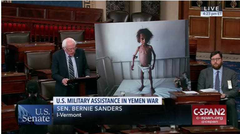 Senator Bernie Sanders urges his colleagues to support his Yemen resolution in front of an enlarged photo of a malnourished Yemeni child.