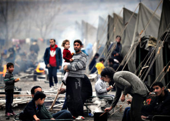 A Syrian refugee holds a baby in a refugee camp set in the town of Harmanli, south-east of Sofia