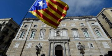 A person waves a Catalan pro-independence flag in front of the 'Generalitat' palace (Catalan government headquarters) in Barcelona, Spain