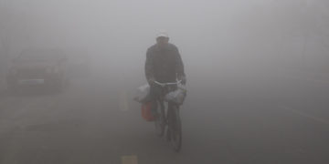 A man cycles in the smog caused by air pollution in China