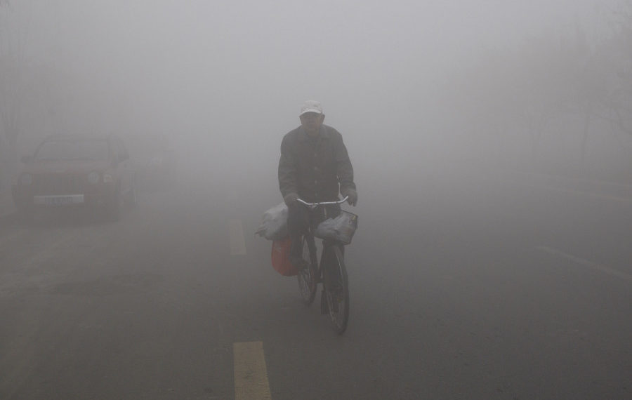 A man cycles in the smog caused by air pollution in China