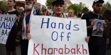 An Armenian man holds a placard reading "Hands off Karabakh" during a rally in Yerevan in 2016
