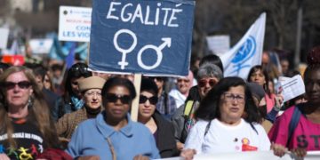 A woman holds a banner reading "Equality" during an International Women’s Day demonstration in the southern French city of Marseille