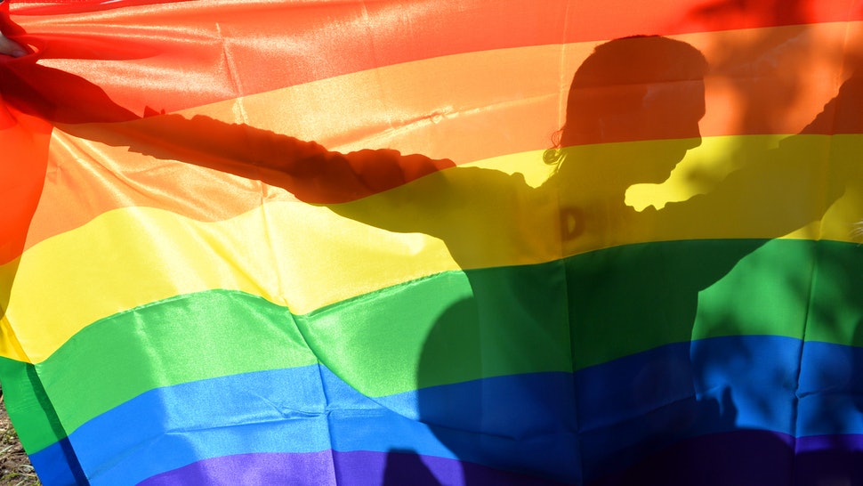 Man holding up a colored LGBT flag