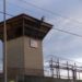 A guard tower rises above the barb-wired walls of a U.S. prison. Photo: AFP