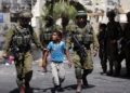 Israeli soldiers arrest a young Palestinian boy following clashes in the center of the West Bank town of Hebron, on June 20, 2014