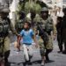 Israeli soldiers arrest a young Palestinian boy following clashes in the center of the West Bank town of Hebron, on June 20, 2014