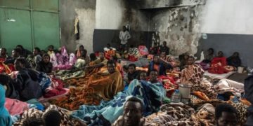 African migrants sit in a packed room with their beds and blankets, at the Tariq Al-Matar detention centre on the outskirts of the Libyan capital Tripoli
