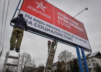 Workers fix an election campaign billboard of the Socialist Party reading "We vote the star, we vote the socialists. It is logical" in Chisinau on February 13, 2019