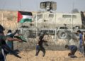 Palestinian demonstrators throw stones at Israeli security forces during protests along the border with Israel in the Gaza Strip on July 12, 2019