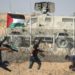 Palestinian demonstrators throw stones at Israeli security forces during protests along the border with Israel in the Gaza Strip on July 12, 2019