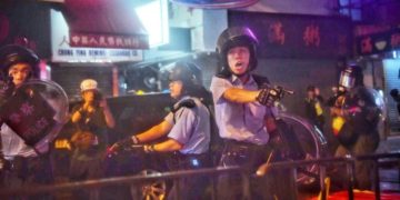 Police officers point their sidearms at protesters during violent clashes in Tseun Wan, Hong Kong