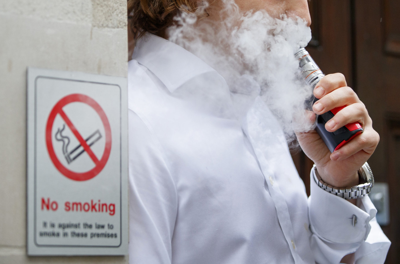 A smoker is engulfed by vapours as he smokes an electronic vaping machine during lunch time in central London on August 9, 2017.