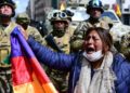 A Bolivian woman stands in front of a security forces at a mostly indigenous protest on November 16, 2019 against the coup that deposed President Evo Morales. Photo: AFP