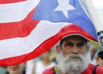 A man carries a Puerto Rican flag during a protest against the referendum for Puerto Rico political status in San Juan, on June 11, 2017.