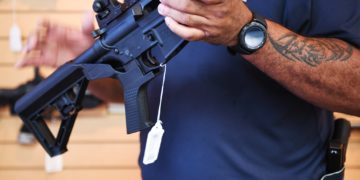 Senior Sales Staff Mark Warner shows a bump stock installed on an AR-15 rifle at Blue Ridge Arsenal in Chantilly, Virgina, on October 6, 2017.