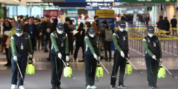 Cleaners spray disinfectant in the Customs and Immigration area of Incheon international airport, west of Seoul, South Korea