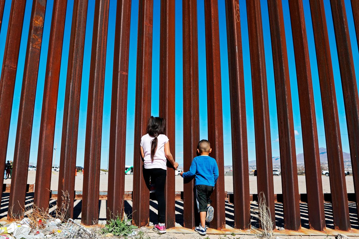 Children look through the border fence in Ciudad Juarez at the US-Mexico border on January 31, 2020