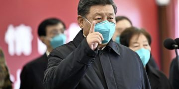 Chinese President Xi Jinping wearing a mask as he gestures to a coronavirus patient and medical staff via a video link at the Huoshenshan hospital in Wuhan, in China's central Hubei province on March 10, 2020