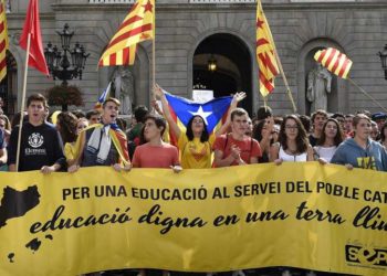 Catalan students hold a banner reading "For an education to serve the Catalan people".