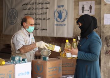 A women receives soap and other supplies from a World Food Programme station in Aleppo, Syria