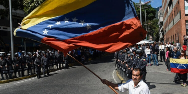 A man holding a Venezuelan national flag during a protest against President Nicolas Maduro.