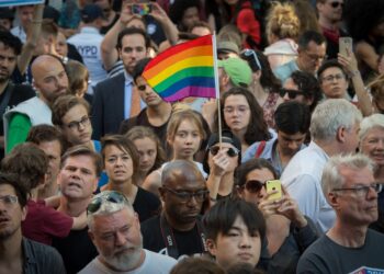 People wave flags during a vigil in reaction to the mass shooting at a gay nightclub in Orlando, Florida on June 12, 2016. Photo: Bryan R. Smith/AFP via Getty Images