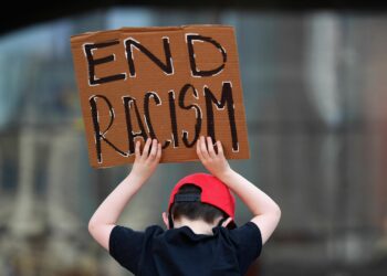 A child holds a poster against racism.