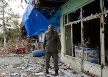 A local resident stands by a cafe damaged by shelling in the settlement of Dord Yol in Azerbaijan.