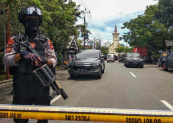 An Indonesian anti-terror policeman stands guard following an explosion outside a church in Makassar, March 28, 2021.