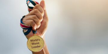 Person holding medal saying "World's Worst Leader"