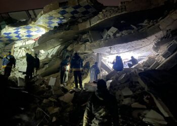 Syrian rescuers and civilians search for victims and survivors amid the rubble of a collapsed building, in the rebel-held northern countryside of Syria's Idlib province on the border with Turkey, early on February 6, 2023. Syrian rescuers (White Helmets) and civilians search for victims and survivors amid the rubble of a collapsed building