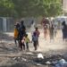 Children and families flee their neighbourhoods amid fighting in Khartoum, Sudan