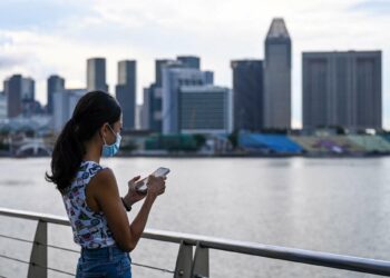 A woman in Singapore checks her mobile