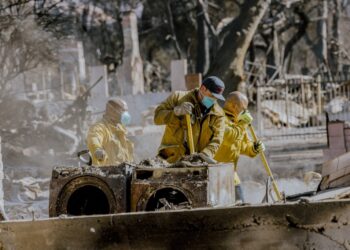 Pasadena firefighters clean the debris of a burned home on January 10, 2025.