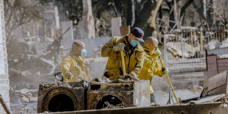 Pasadena firefighters clean the debris of a burned home on January 10, 2025.