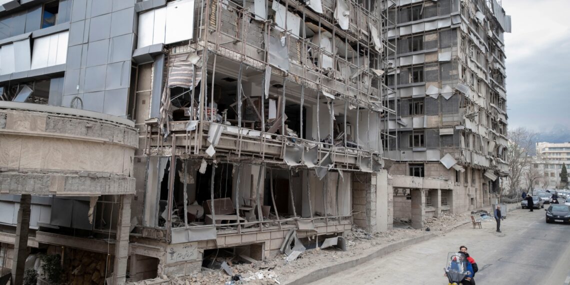 An Iranian motorcyclist rides past the Gandhi Hospital, which is damaged after US-Israeli strikes on a state TV telecommunication tower nearby in Tehran, Iran, on March 2, 2026.
